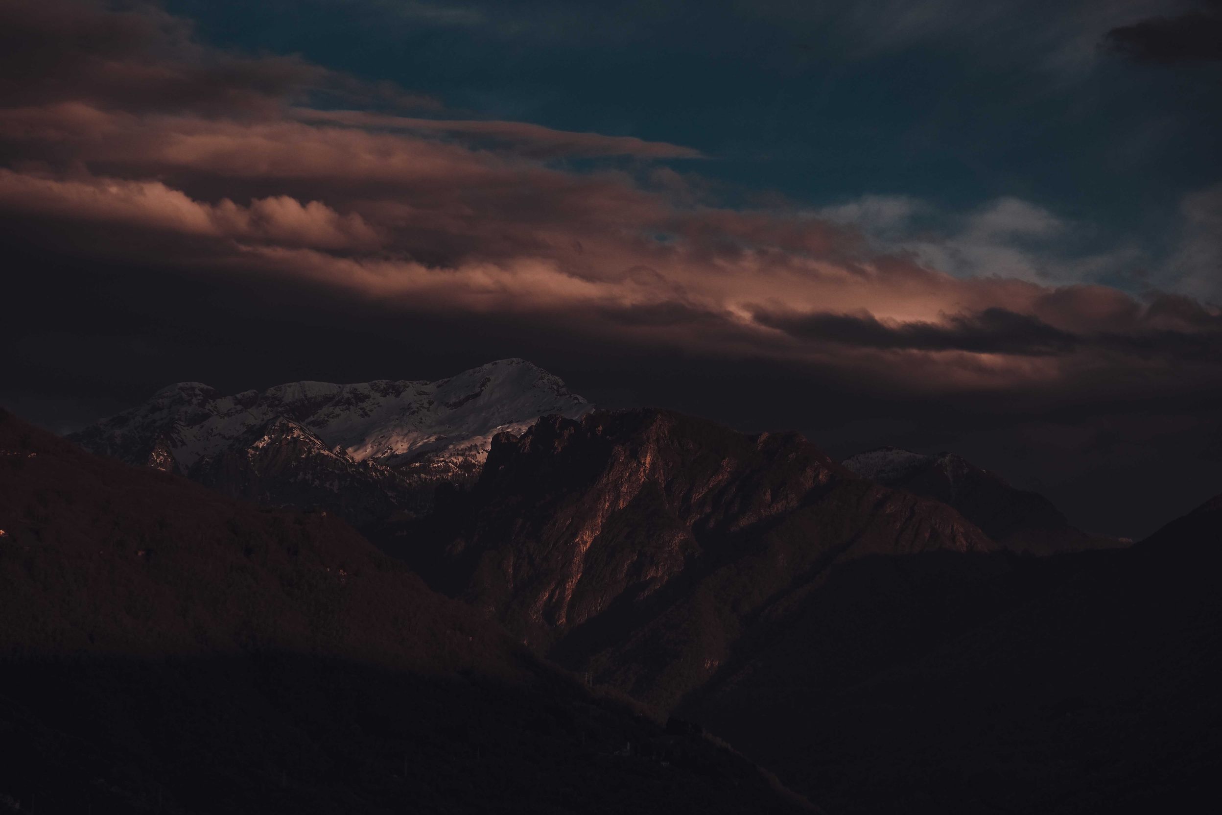 Mountain peaks with snow in dark sunset